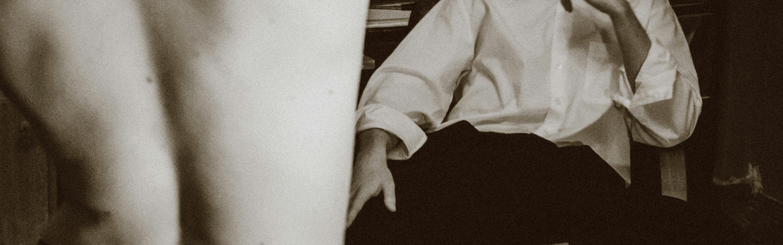 A man sitting comfortably on a chair adjacent to a mirror, capturing a peaceful moment of self-reflection