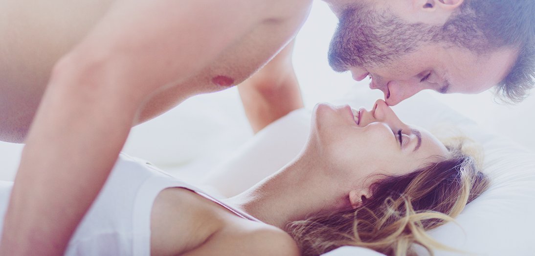 Couple embracing in white bed