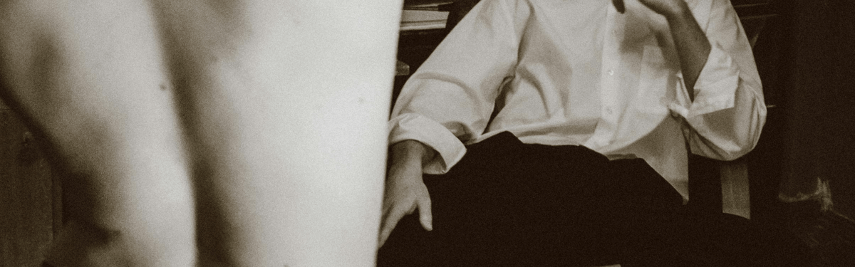 A man sitting comfortably on a chair adjacent to a mirror, capturing a peaceful moment of self-reflection
