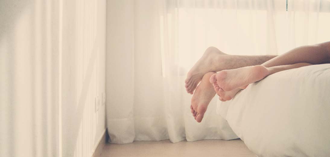 Legs hanging off the end of a bed